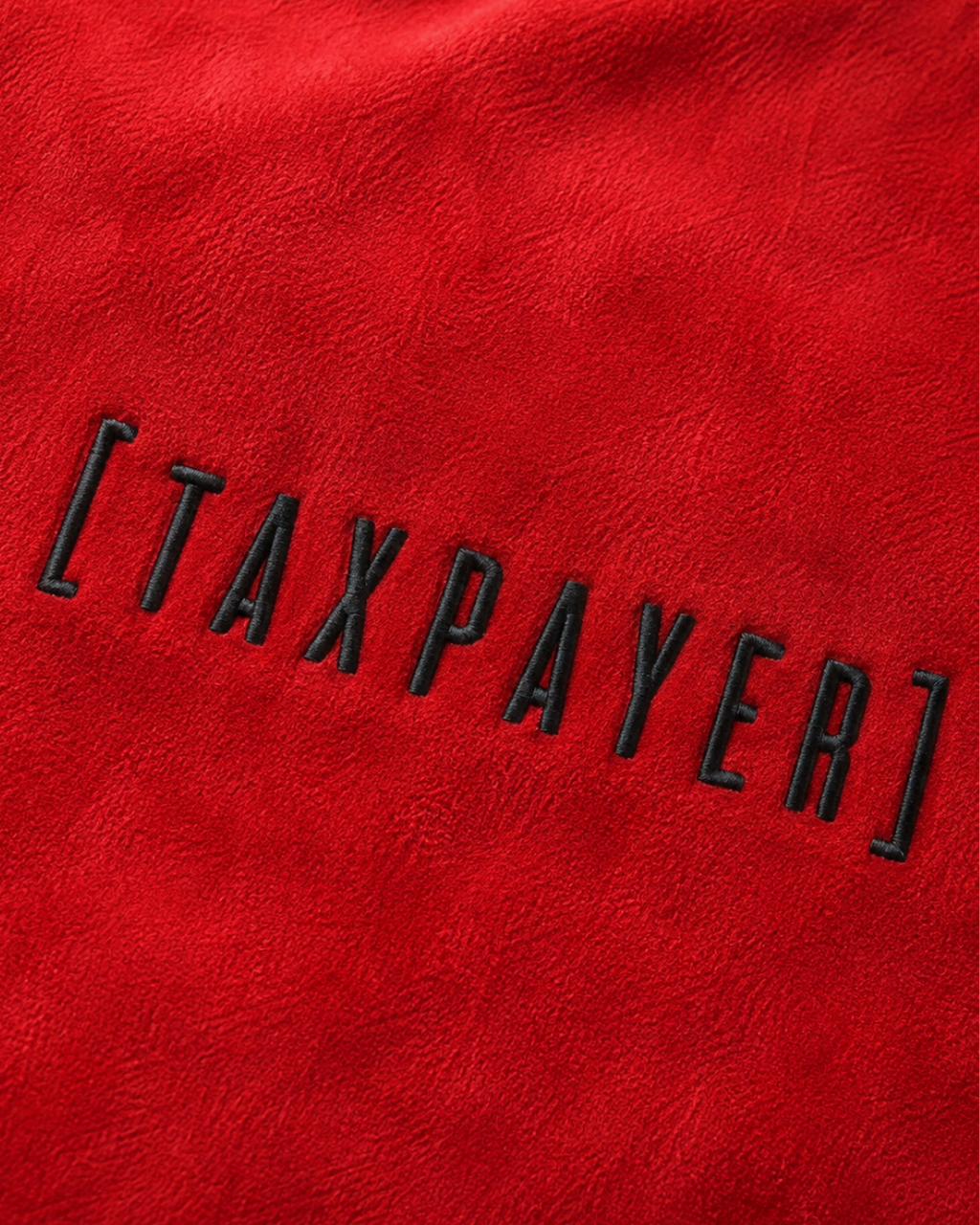 A close-up of a red textured fabric with the word "[TAXPAYER]" embroidered in black outlined letters across the center.